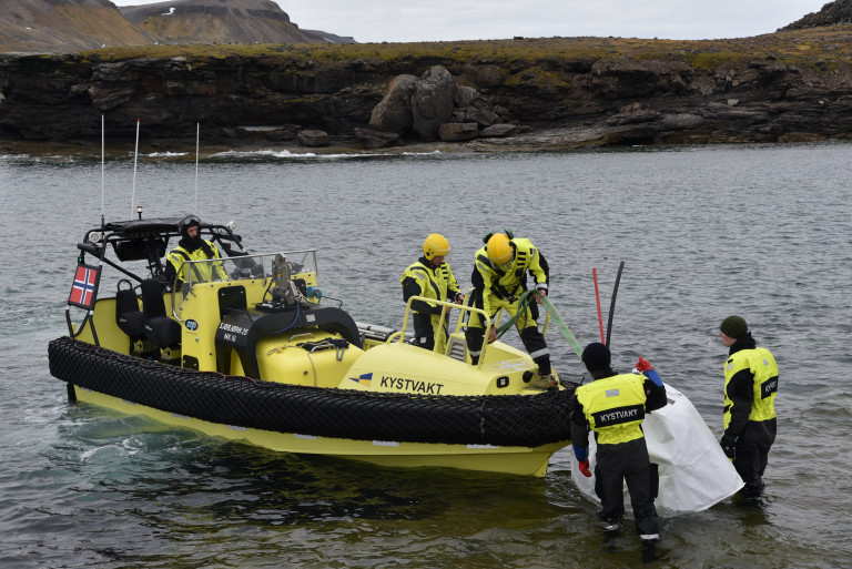 Over 600 kilo søppel tas elegant ut av Kystvaktens raske menn og løftes om bord på Kystvaktskipet for transport til fastlandet. Unikt fint vær bidro til at området lot seg rydde- denne gangen. Foto: Audun Narvestad/ SALT